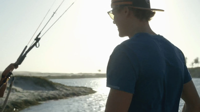 a man standing next to a body of water holding a fishing pole