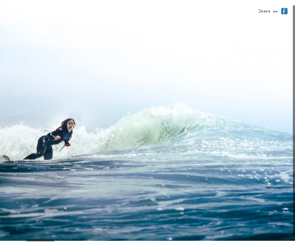 a woman riding a wave on top of a surfboard