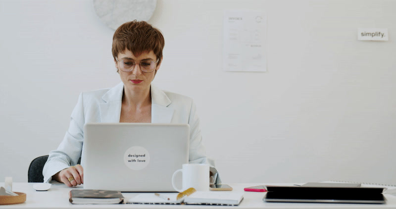 a woman sitting at a desk with a laptop