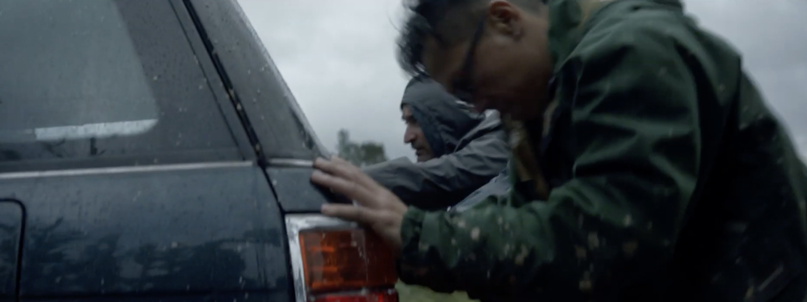 a man leaning on the back of a car