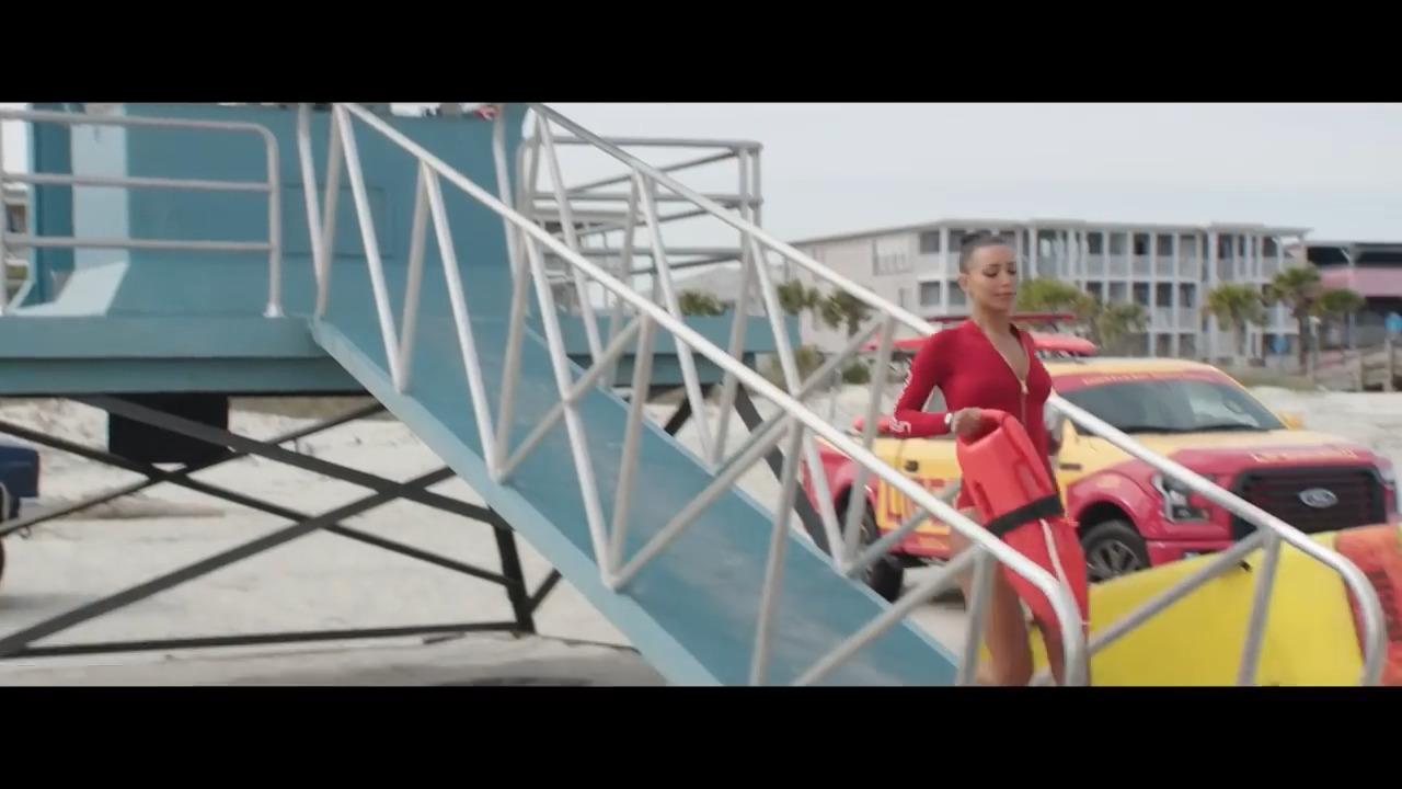 a woman in a red dress walking up a ramp