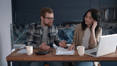 a man and a woman sitting at a table with a laptop