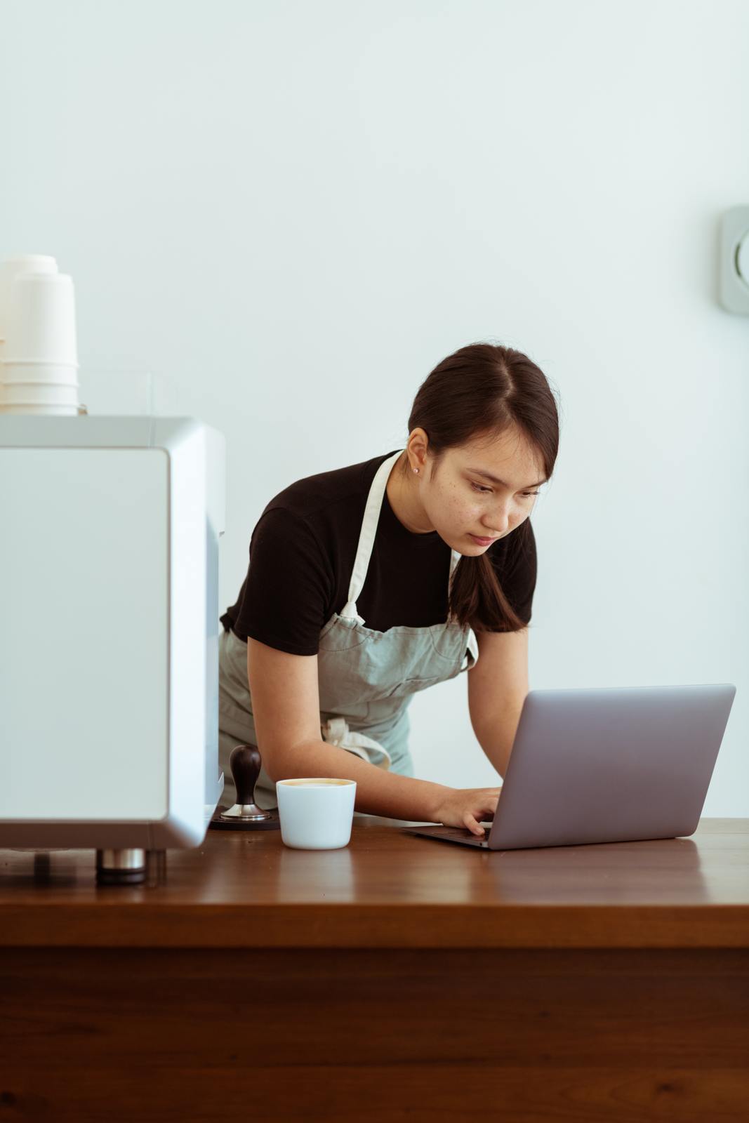 a woman in an apron working on a laptop