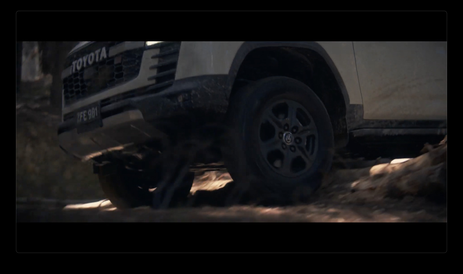 a white truck driving down a dirt road