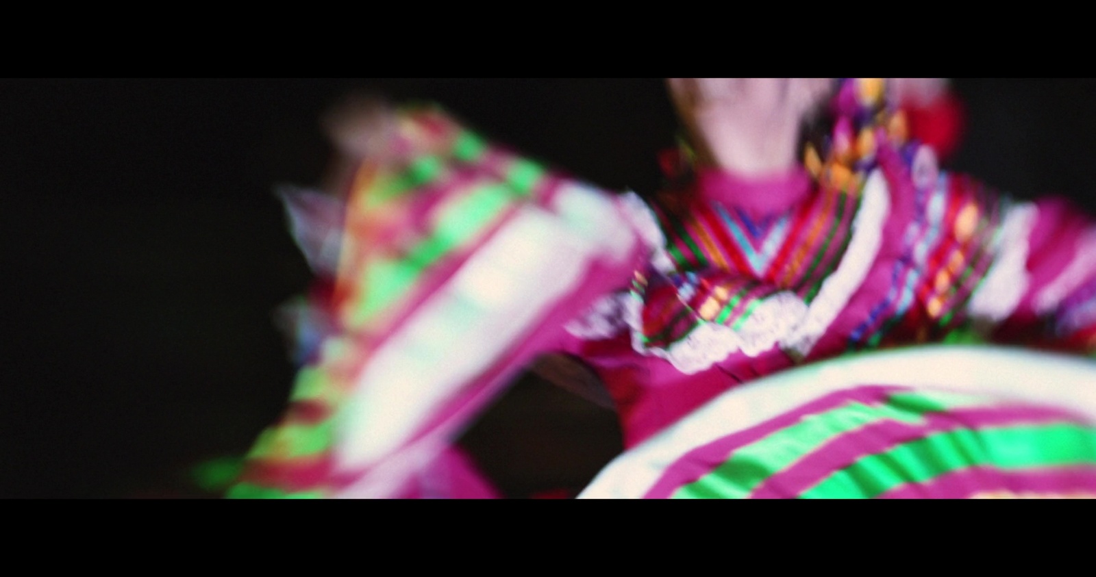 a blurry image of a woman in a colorful dress