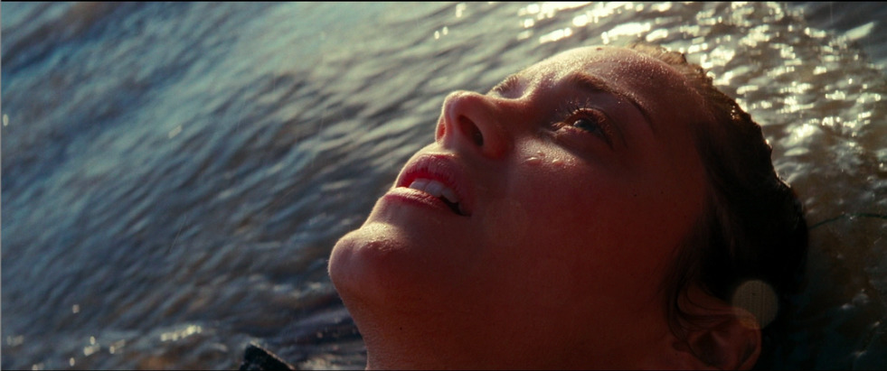 a woman laying in the water with her eyes closed