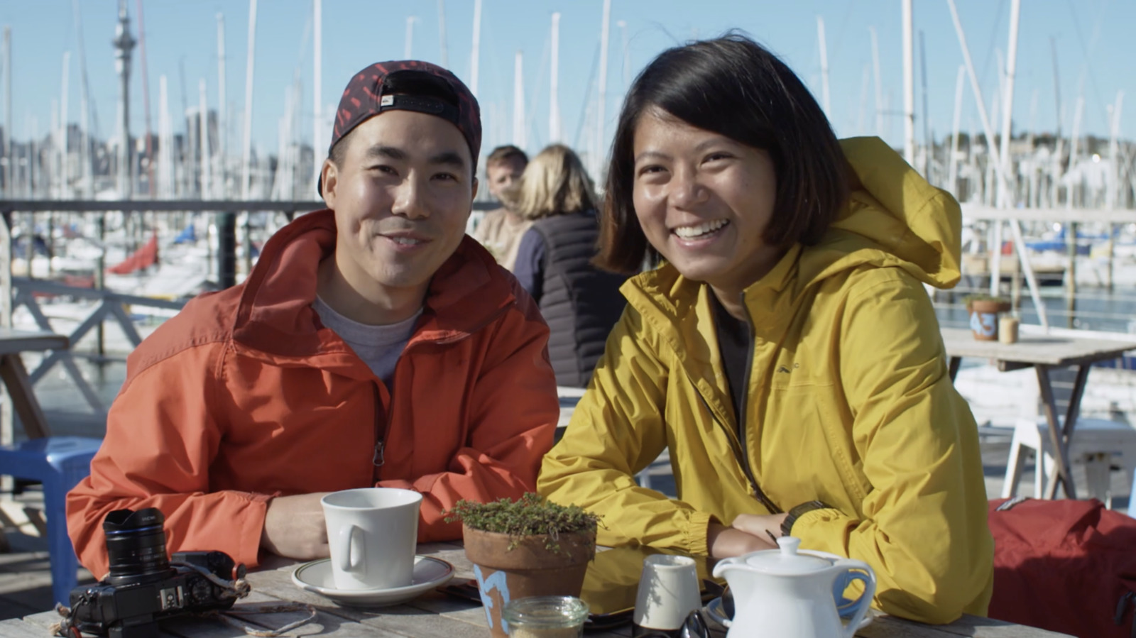 two people sitting at a table with cups of coffee