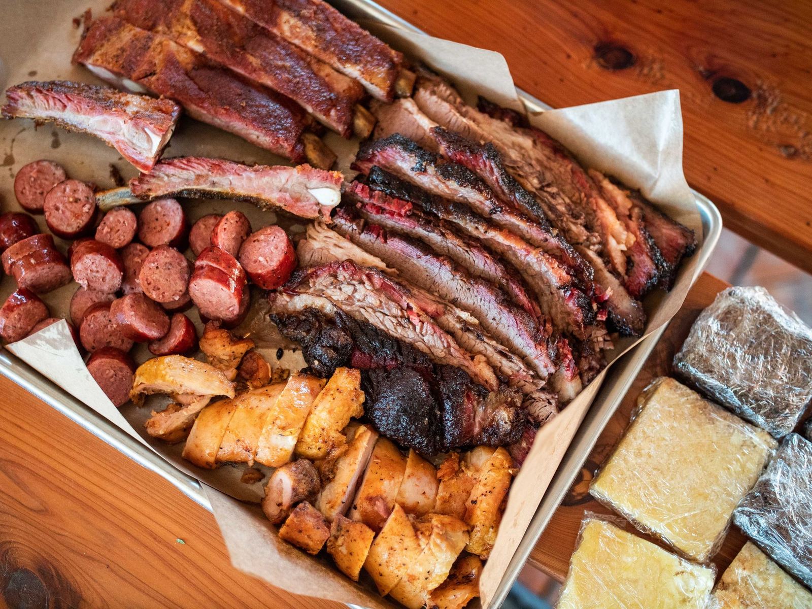 a box filled with meat and potatoes on top of a wooden table