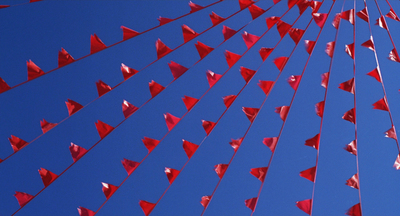 a group of red flags flying in the sky