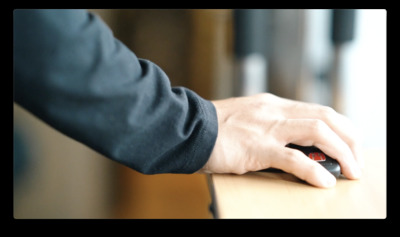 a person's hand on a mouse on a table