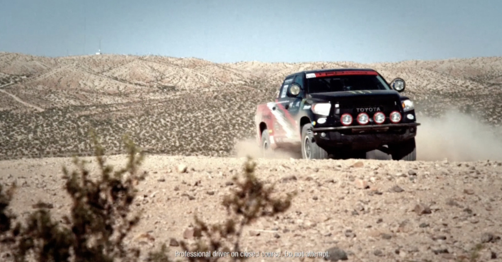 a truck driving through the desert on a sunny day