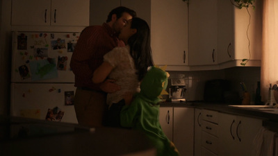 a man and a woman kissing in a kitchen