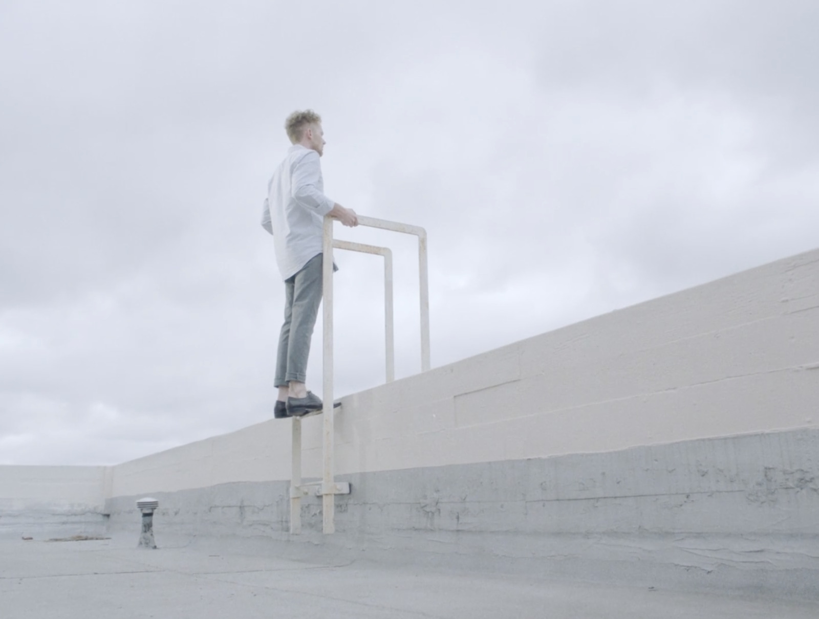 a man standing on a ladder on a cloudy day