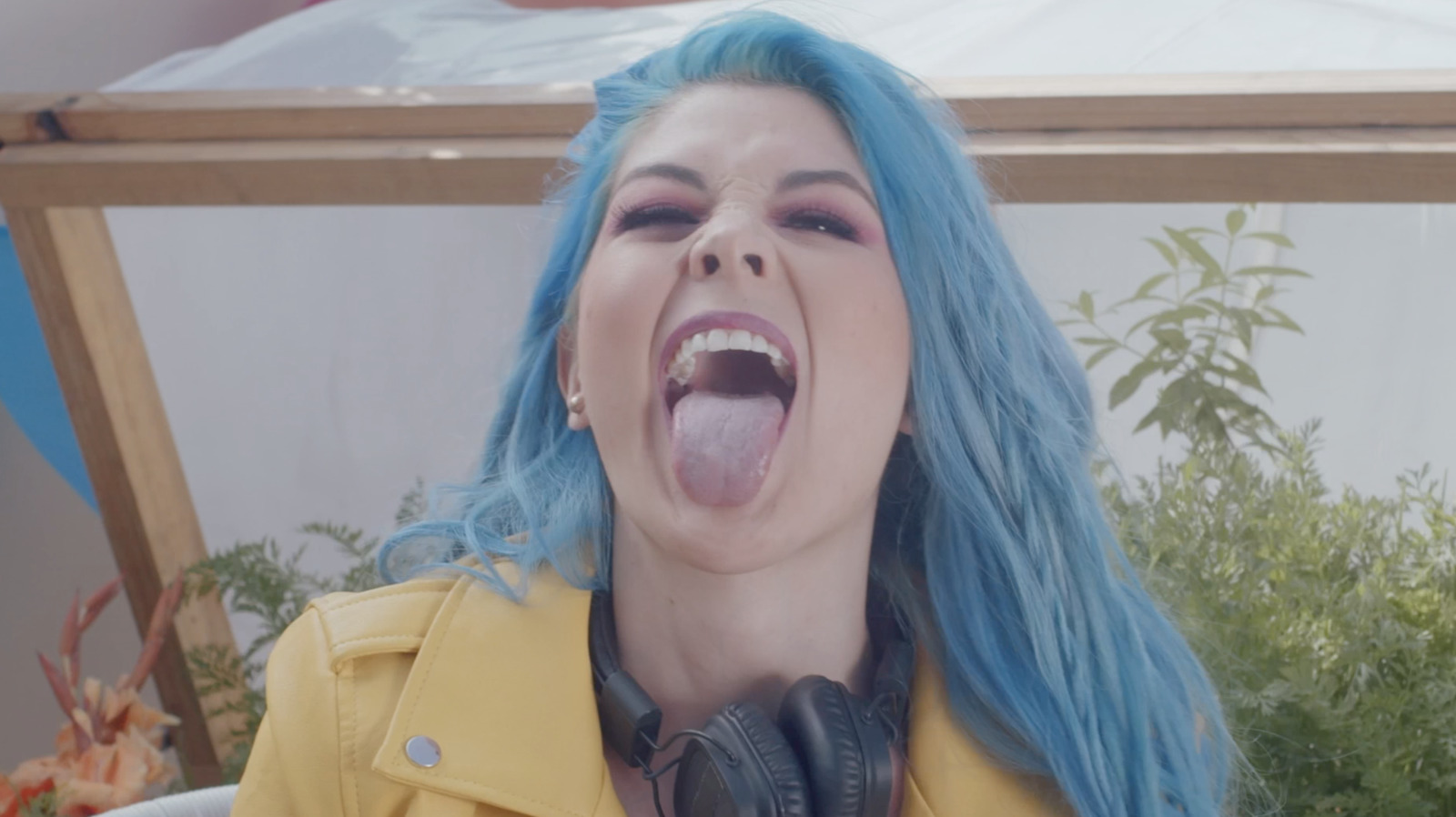 a woman with blue hair is making a funny face