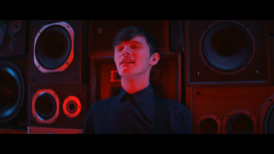 a man standing in front of a bunch of speakers