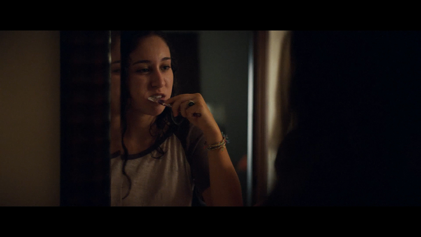 a woman brushing her teeth in front of a mirror