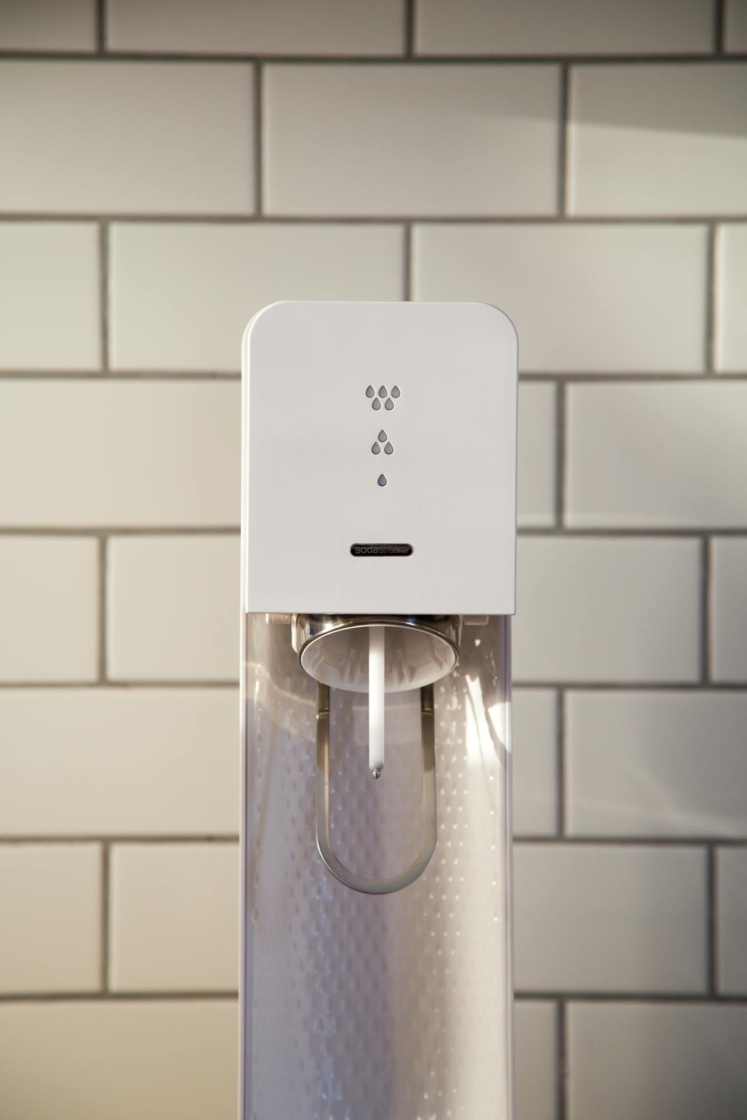 a white water dispenser on a tiled wall