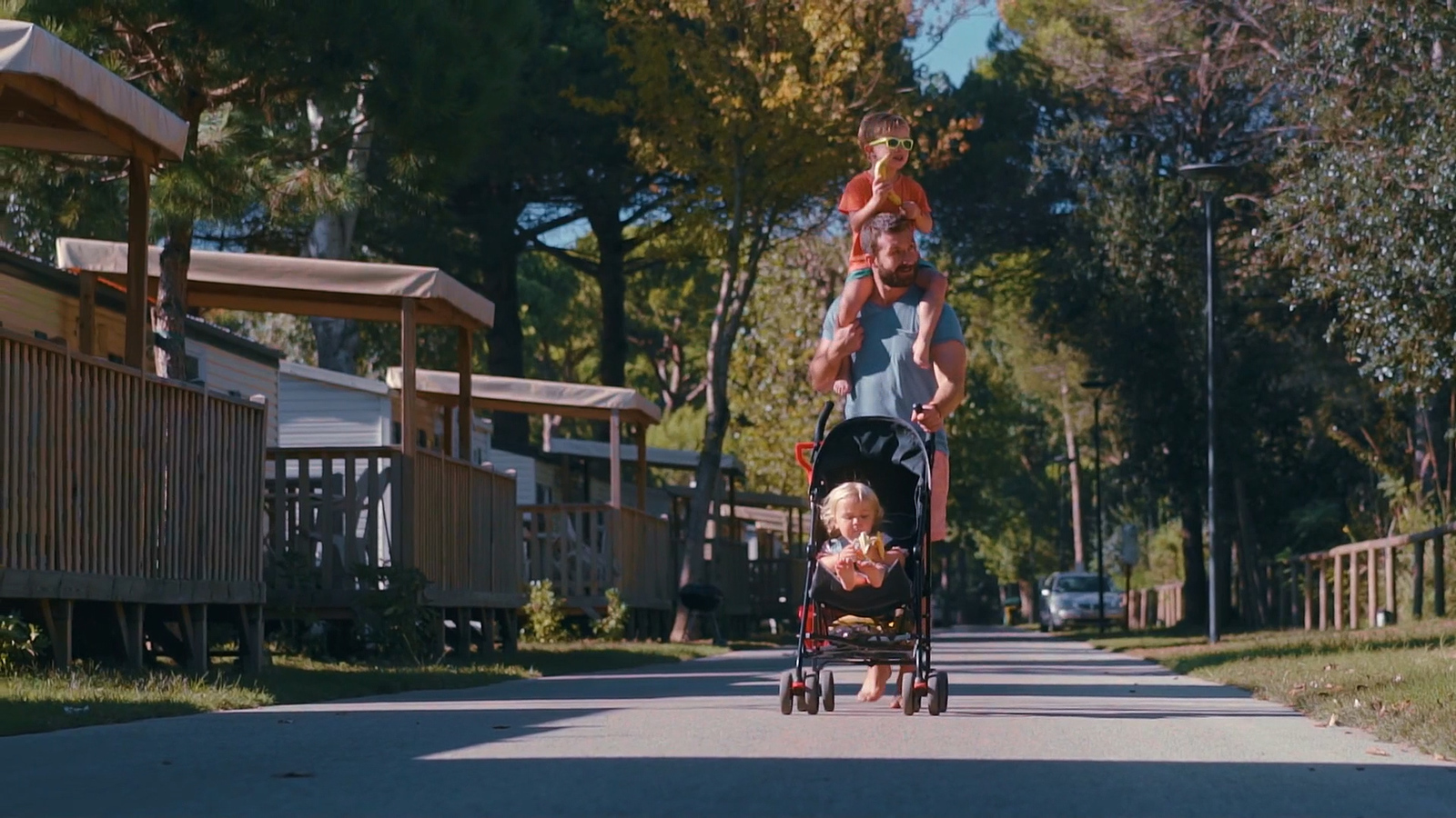 a woman pushing a stroller with two children in it