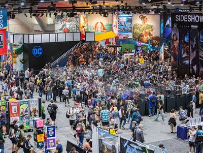 a crowd of people walking around a convention hall