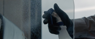 a person in black gloves is holding a mirror