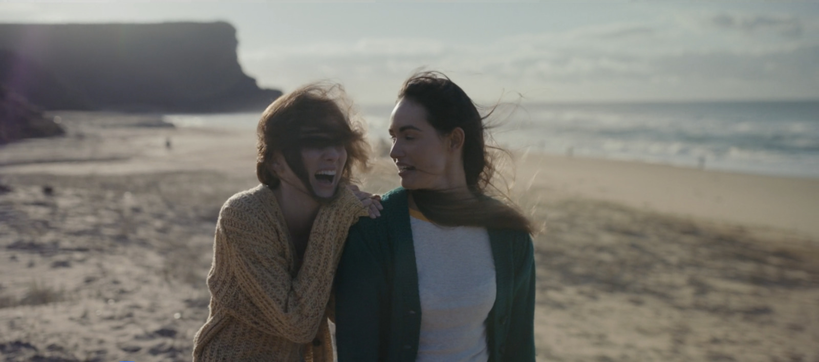 a couple of women standing next to each other on a beach