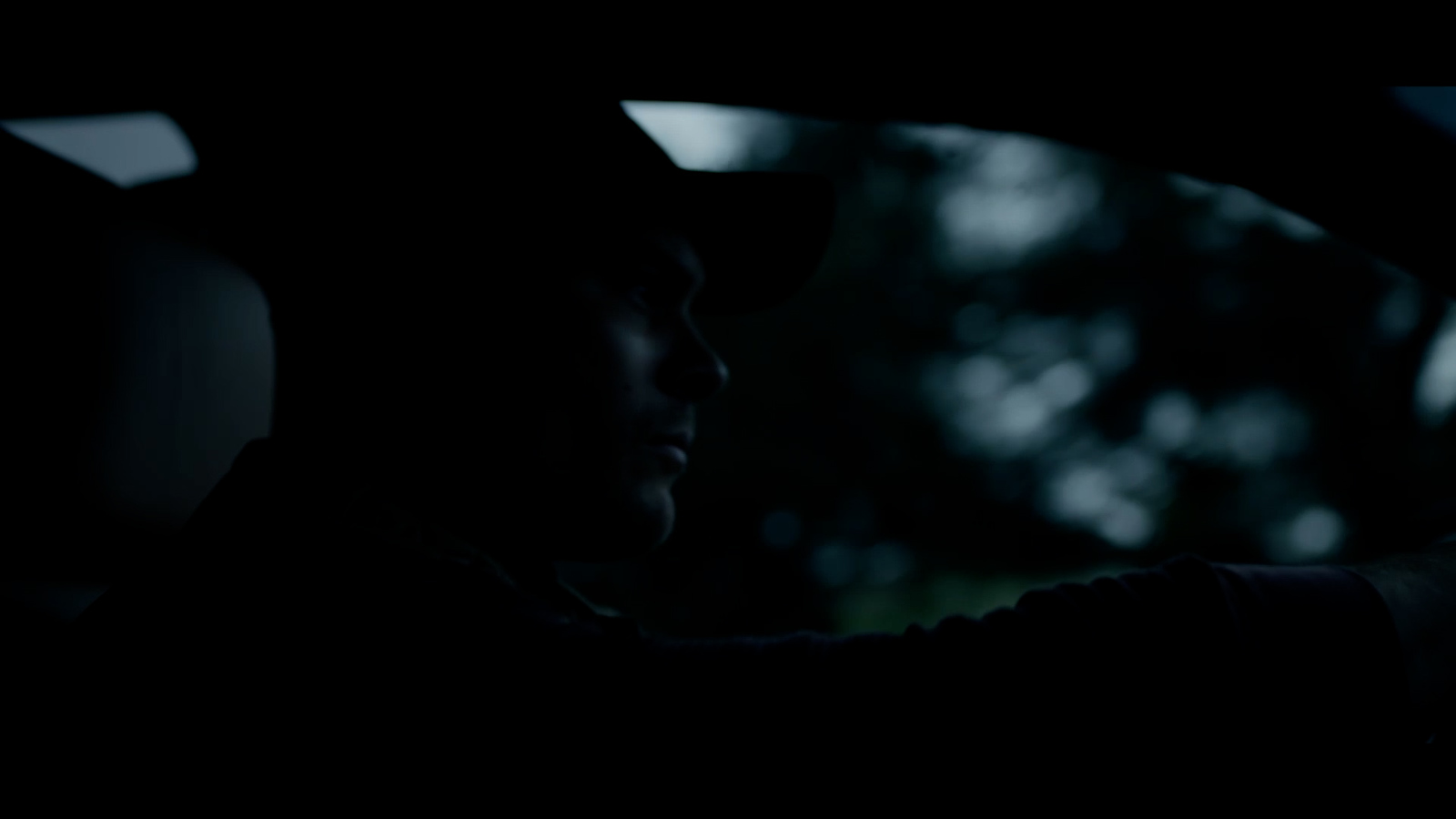 a man driving a car in the dark