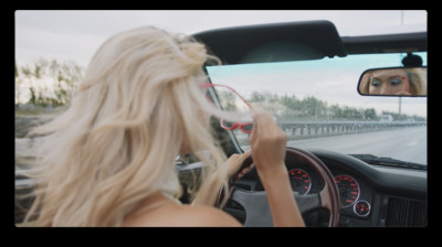 a blonde woman driving a car on a highway