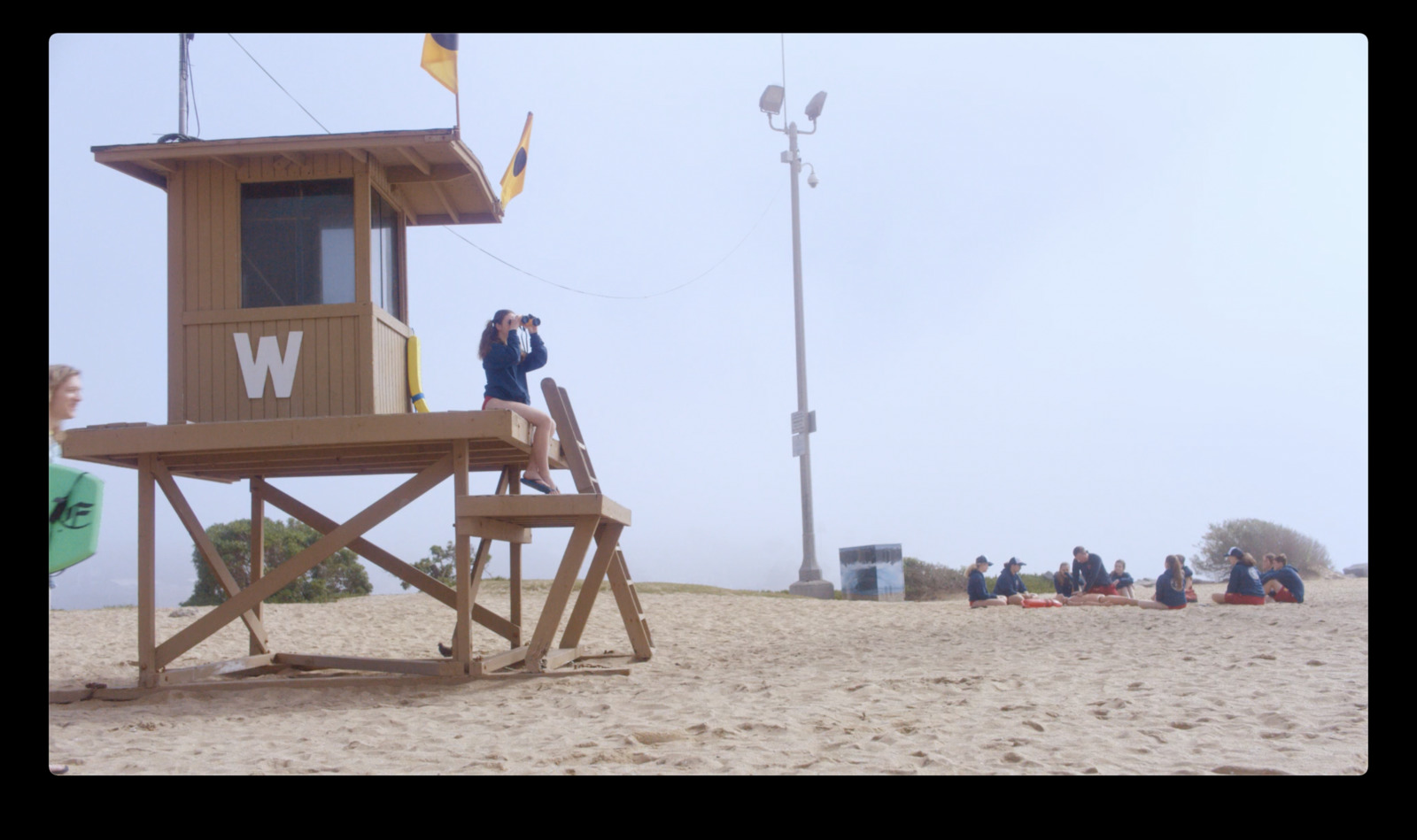 a group of people standing on top of a lifeguard tower