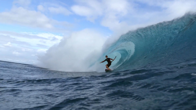 a man riding a wave on top of a surfboard