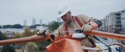 a man wearing a hard hat and working on a pipe