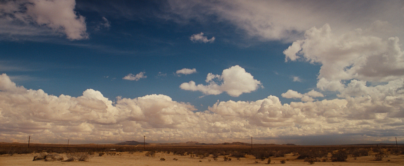 a desert landscape with clouds in the sky