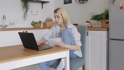 a woman sitting at a table with a laptop