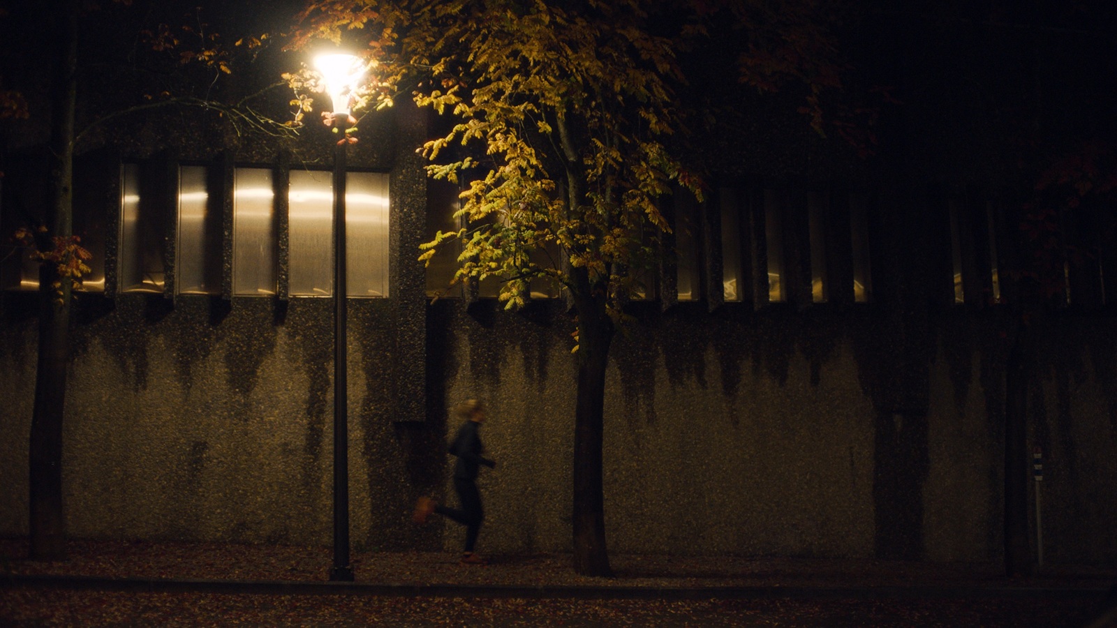 a person walking down a street at night