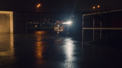 a truck driving down a wet road at night