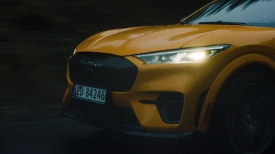 a close up of a yellow car driving down a street