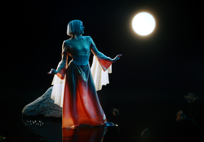 a woman in a long dress standing in the dark