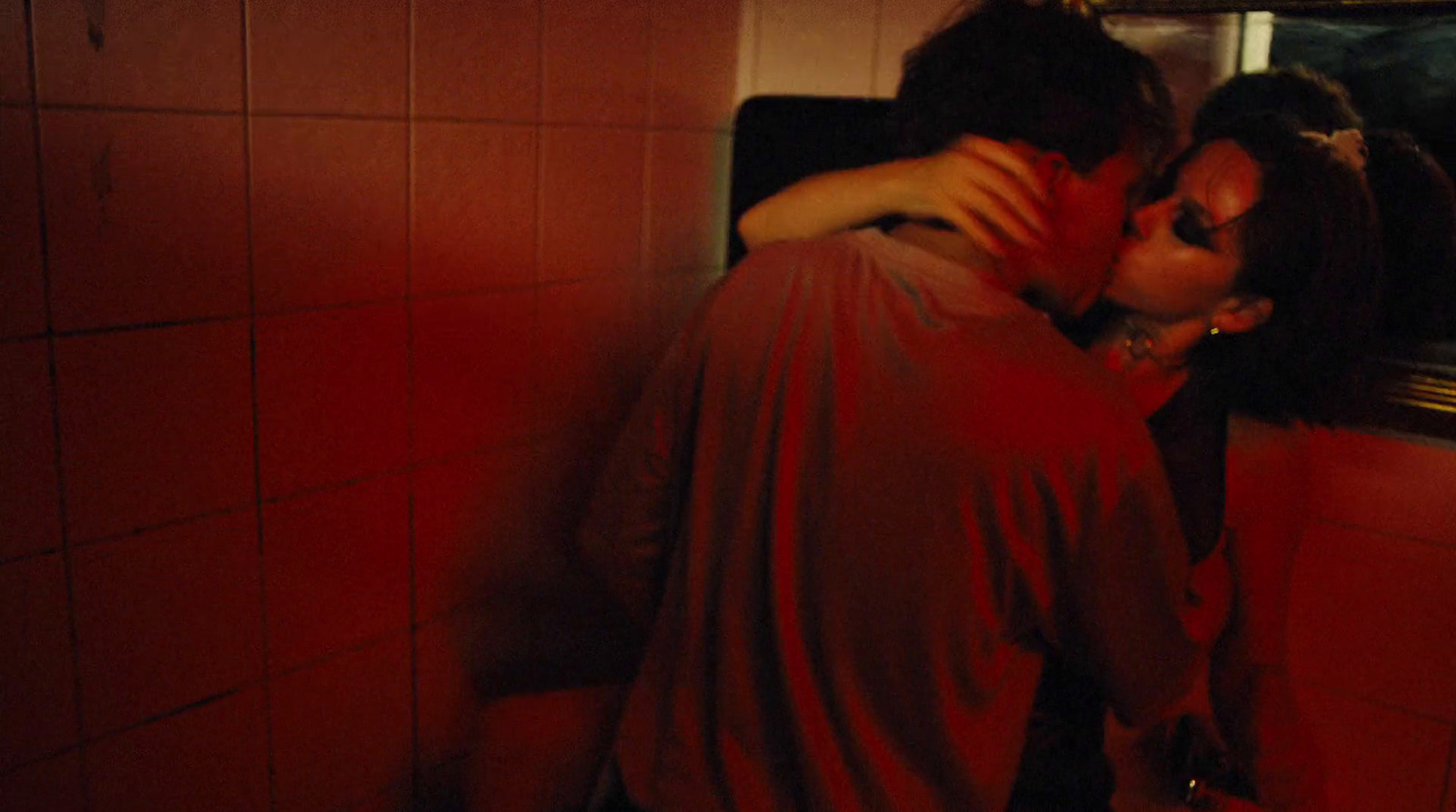 a man and a woman kissing in a bathroom