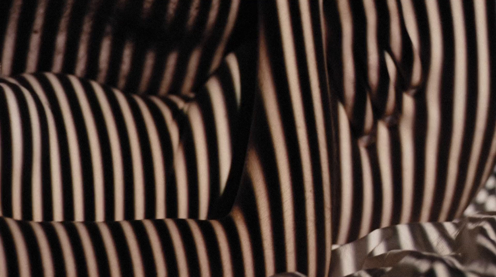 a close up of a striped chair with a tie on it