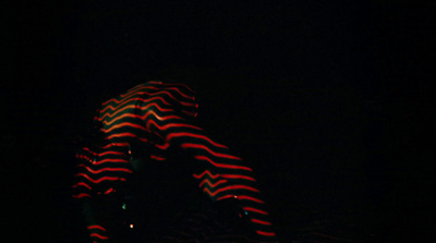 a person standing in the dark holding a snowboard