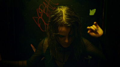 a woman with long hair standing in a dark room