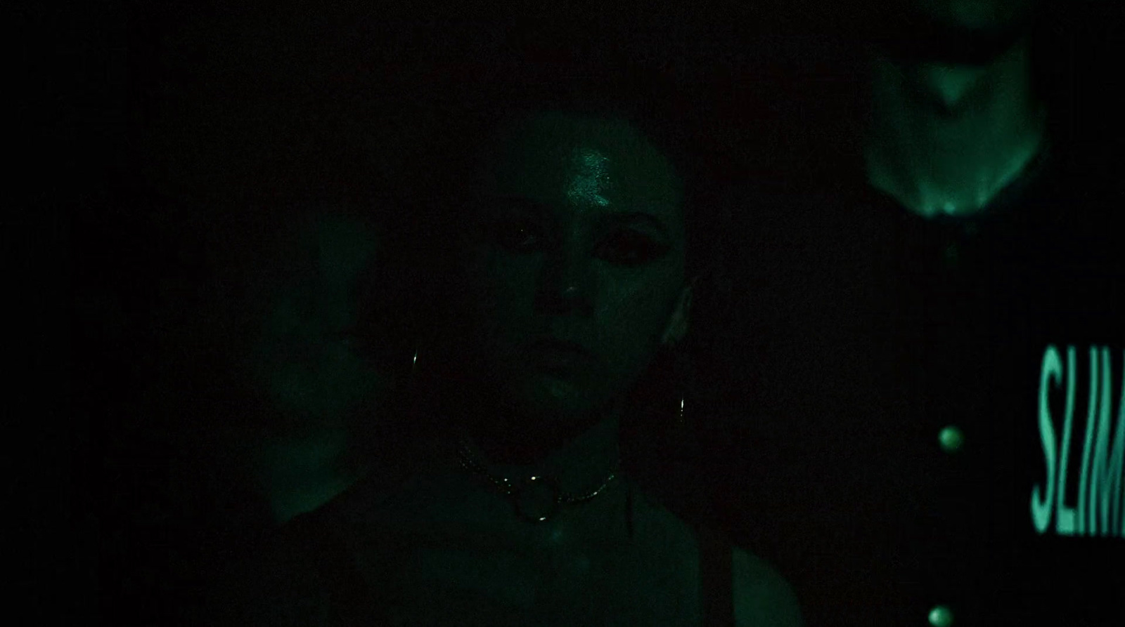 a woman in a dark room with a green glow on her face