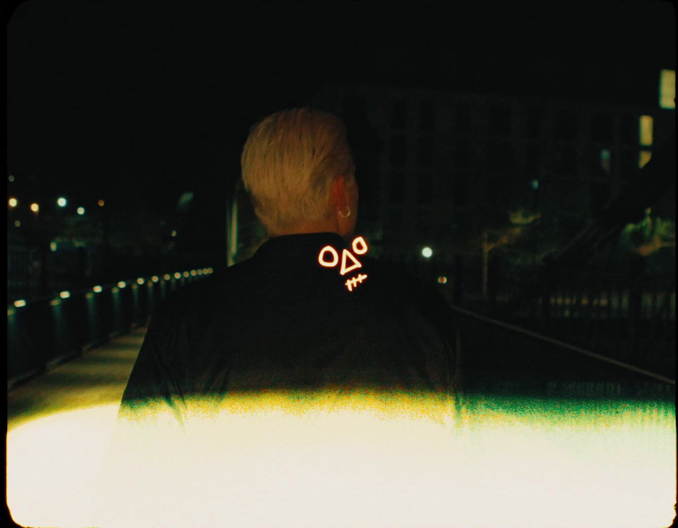 a man standing on a sidewalk at night