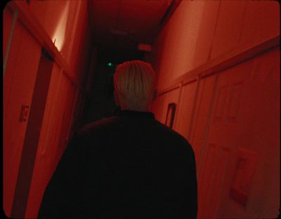 a person standing in a hallway with red light