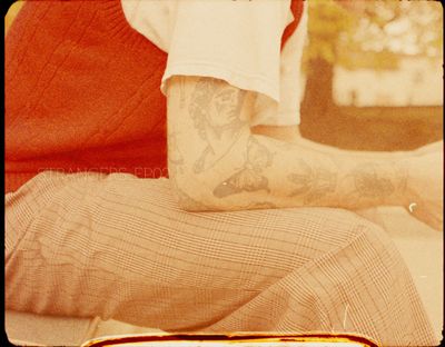 a man with tattoos sitting on a couch