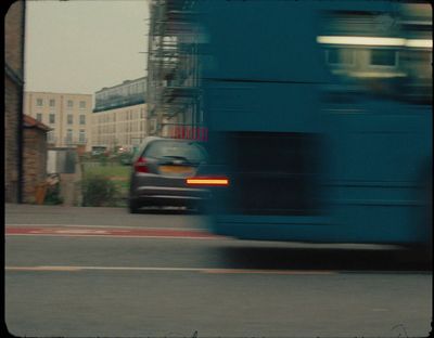 a blue bus driving down a street next to tall buildings