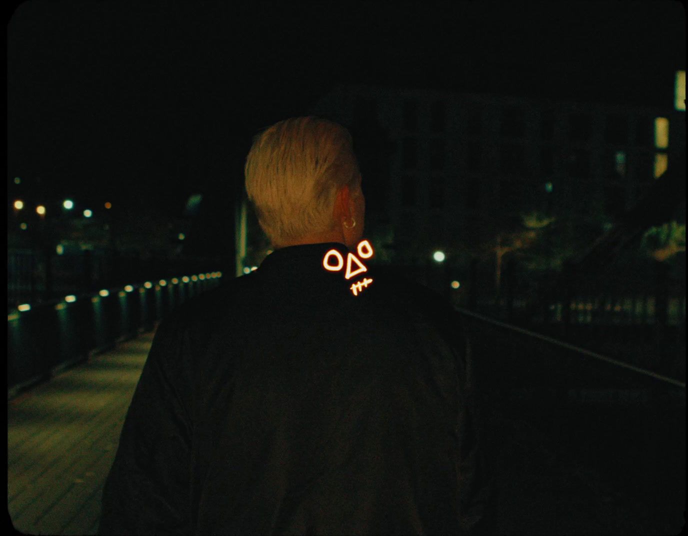 a man standing on a bridge at night