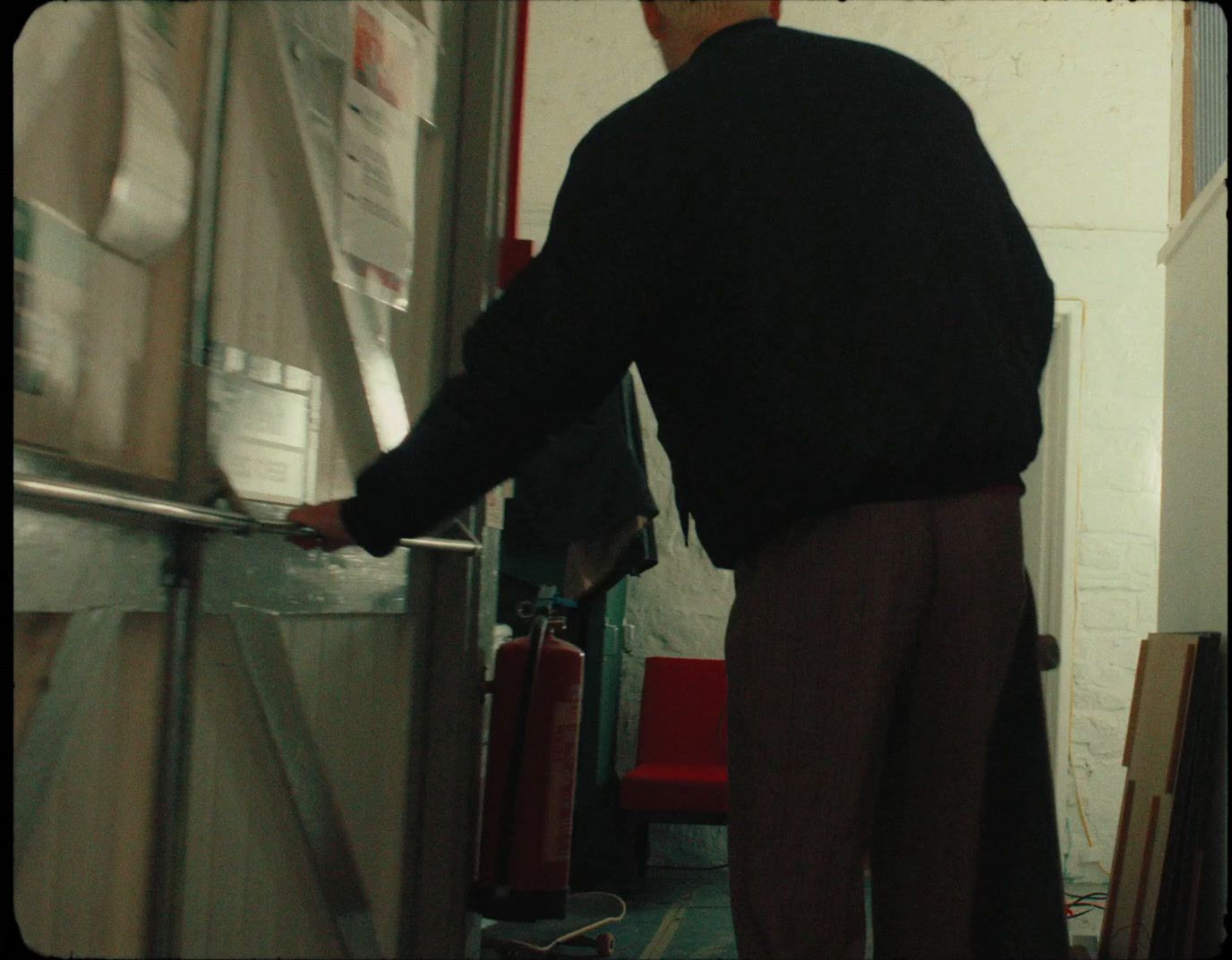 a man in a black sweater is opening a door