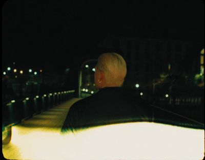 a man sitting on a bench at night