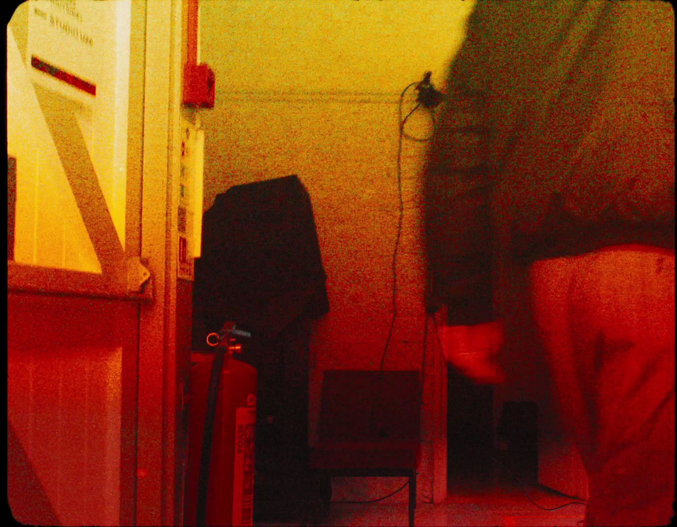 a person standing in a room with a red light