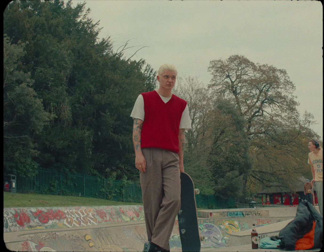 a man holding a skateboard in a skate park